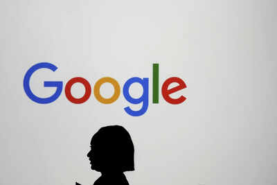 File a woman walks by a giant screen with a logo at an event at the paris google lab on the sideline.jpeg