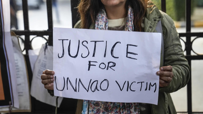 A protester holds a placard during a demonstration against the suspension of the jail term of kuldee.png